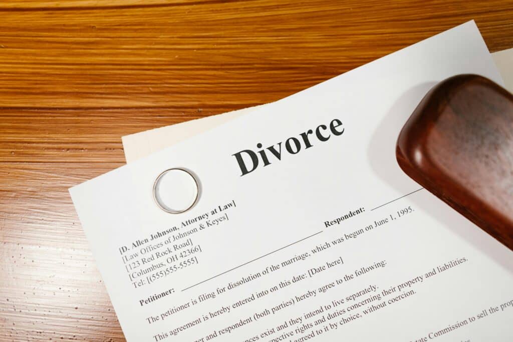 Divorce papers displayed on a table with a ring, symbolizing the toll addiction on marriage leading to separation.
