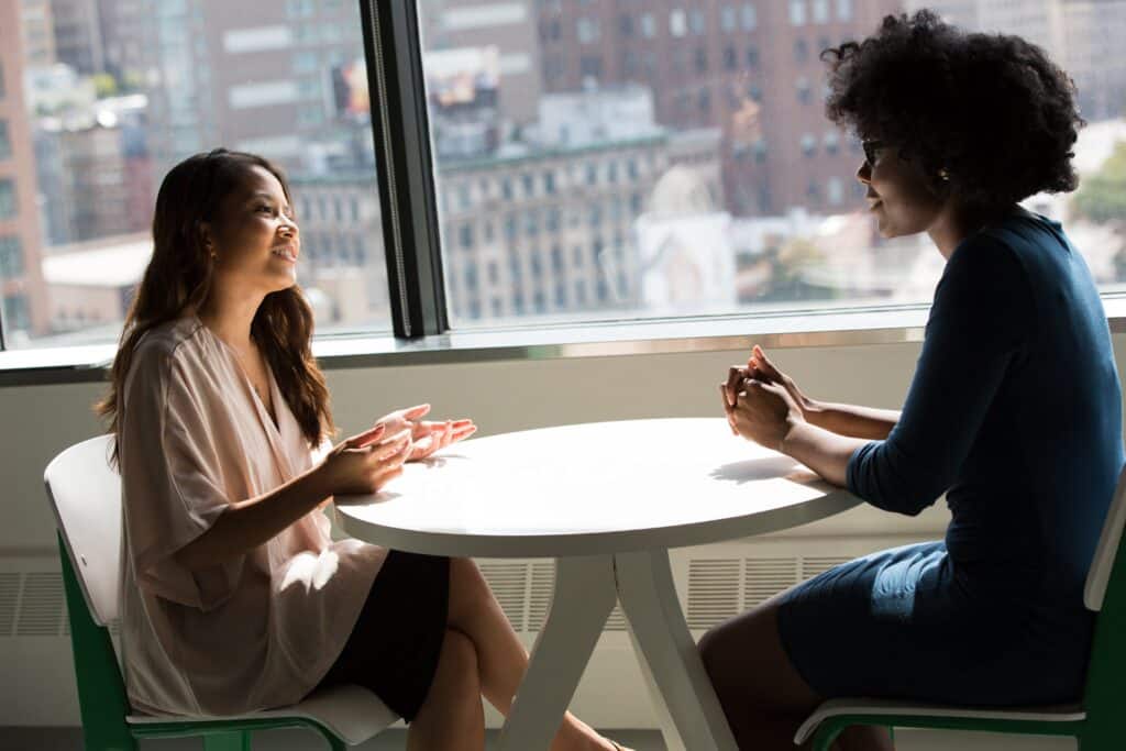 A Black woman talking with another woman, depicting a counseling session focused on addressing opioid use disorder.