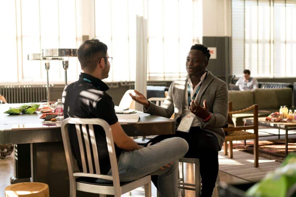 A Black man engaged in a conversation with another man, symbolizing the efforts to raise awareness of opioid use disorder among Black Americans.